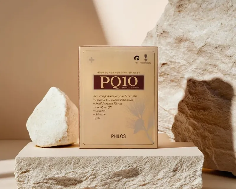 돌 위에 놓인 PQ10 하이드로겔 골드마스크 제품 상자